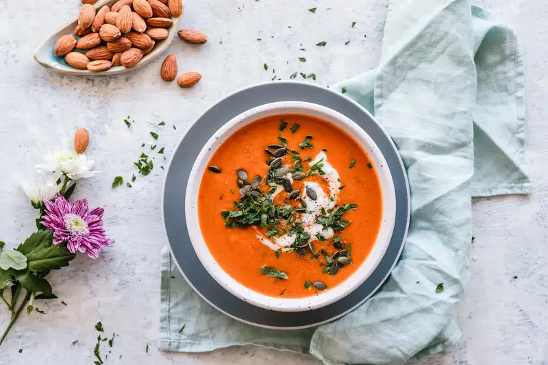 A pot of lentil vegetable soup with bread nearby